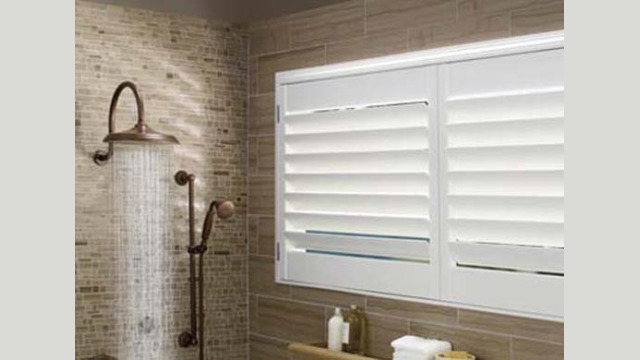 Modern bathroom with shower and window shutters.